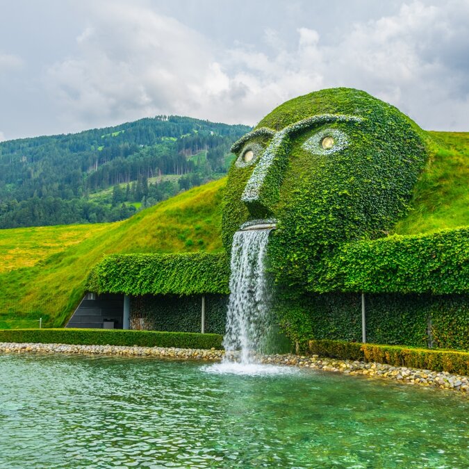 Fontaine avec une tête géante crachant de l'eau dans un bassin aux Mondes du cristal Swarovski à Wattens | © Shutterstock 552829036